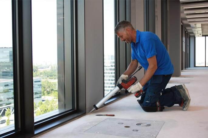 Man die bezig is met duurzaam afdichten van beton in nieuw gebouw