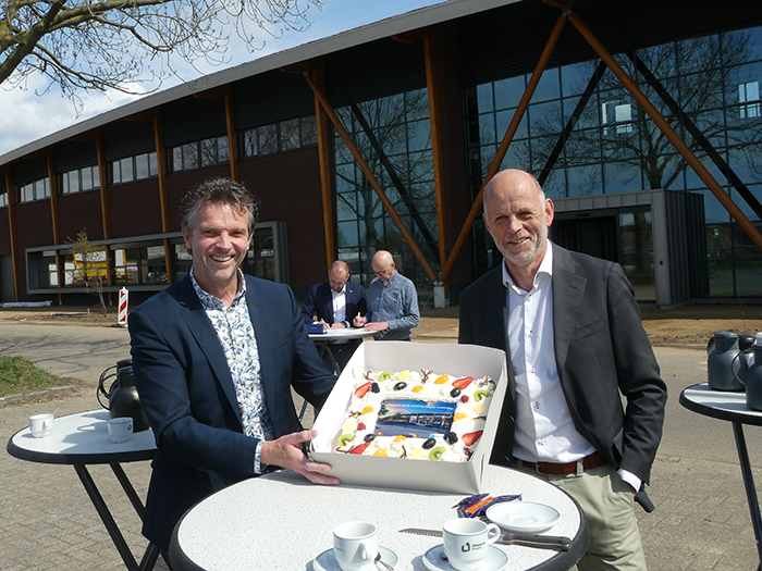 Wybren de Zwart, CEO, krijgt taart overhandigd voor nieuwe gebouw SABA