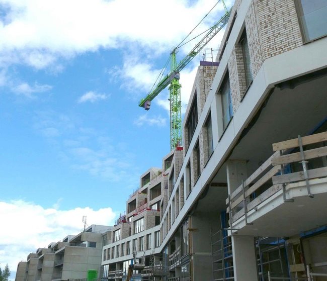 Groene kraan achter gebouw met lucht op achtergrond