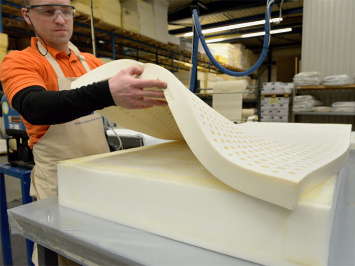 Man assembling foam mattress with hotmelt adhesive